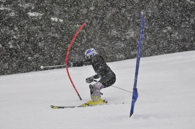 Foto jovem esquiador corre rápido para baixo na cena da neve do inverno