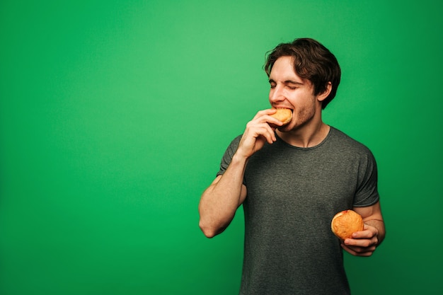 Foto jovem está comendo rosquinha com prazer