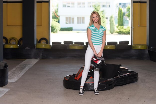 Jovem está dirigindo um carro GoKart com velocidade em uma pista de corrida de playground Go Kart é um esporte a motor de lazer popular