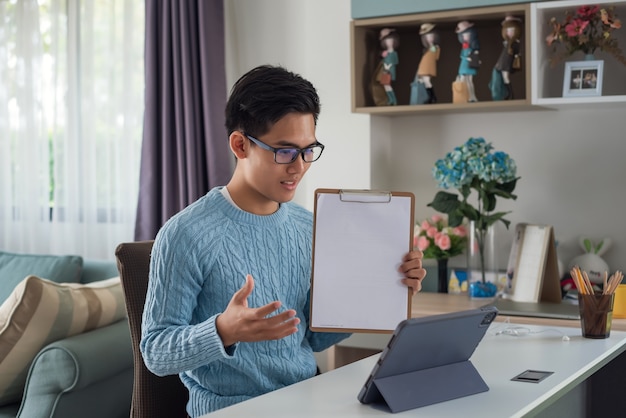 Jovem está estudando online em casa usando um laptop. Documento de aprendizagem.