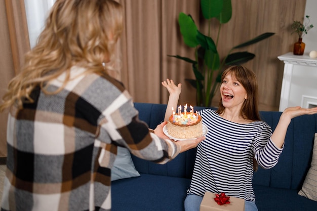 Jovem está feliz com o bolo que sua mãe lhe dá de aniversário