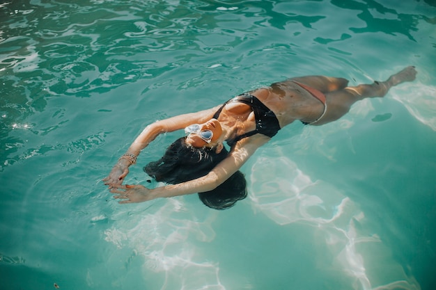 Jovem está relaxando em uma piscina