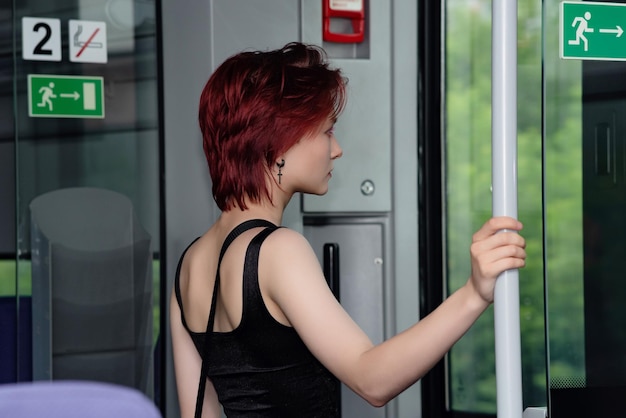 Jovem está se preparando para sair em uma parada de um vagão de trem suburbano