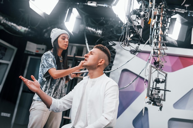 Jovem está se preparando para transmissão online de TV Mulher ajuda com maquiagem