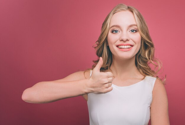 Jovem está segurando o polegar e sorrindo