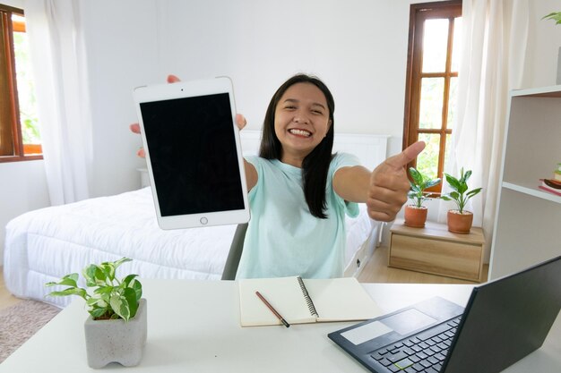 Jovem estudando com laptop no quarto aprendendo em casa