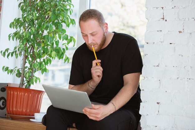 Jovem estudando em casa durante cursos online para análise, financistas, economistas