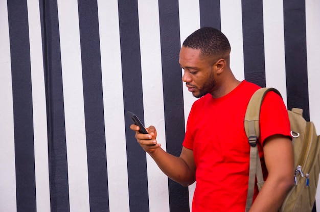 Jovem estudante africano se sentindo animado enquanto opera seu celular