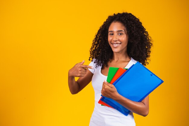 Jovem estudante afro-americana em fundo amarelo