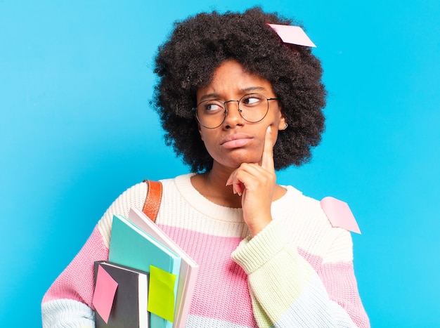 Foto jovem estudante afro com livros e cadernos