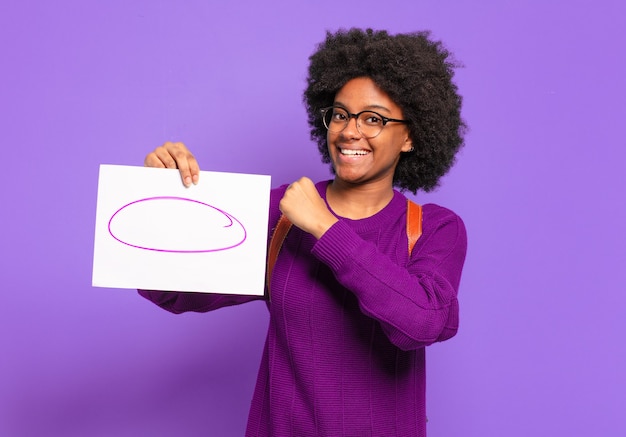 Jovem estudante afro se sentindo feliz, positiva e bem-sucedida, motivada para enfrentar um desafio ou comemorar bons resultados