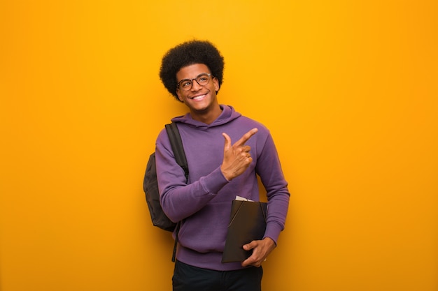 Jovem estudante americano africano, apontando para o lado com o dedo