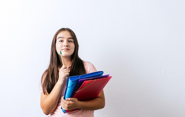 Jovem estudante com pastas coloridas que pensativamente