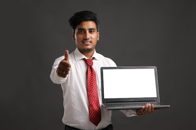 Jovem estudante da Índia, banqueiro ou funcionário mostrando a tela do laptop.