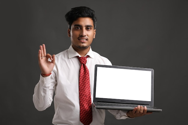 Jovem estudante da Índia, banqueiro ou funcionário mostrando a tela do laptop.