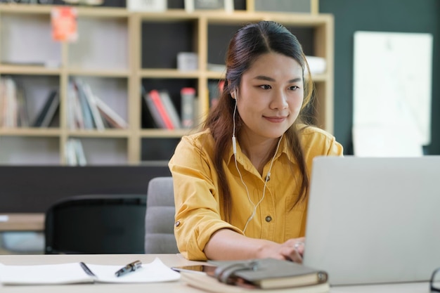 Foto jovem estudante de colégio usando computador e dispositivo móvel estudando on-line