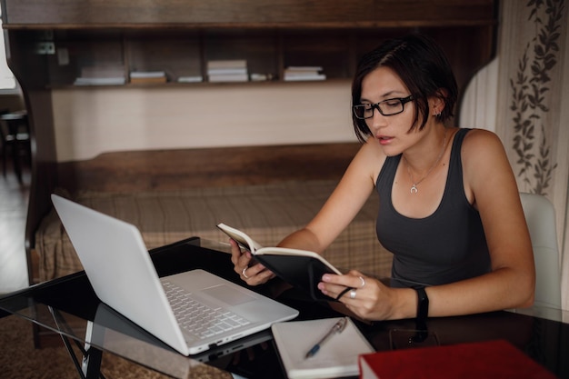 Foto jovem estudante de óculos usando laptop se comunica na internet com professores