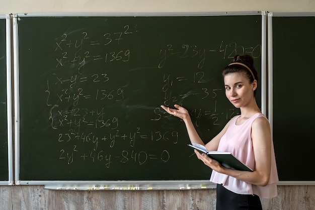 Jovem estudante explica resolvendo fórmula matemática de altura no quadro-negro