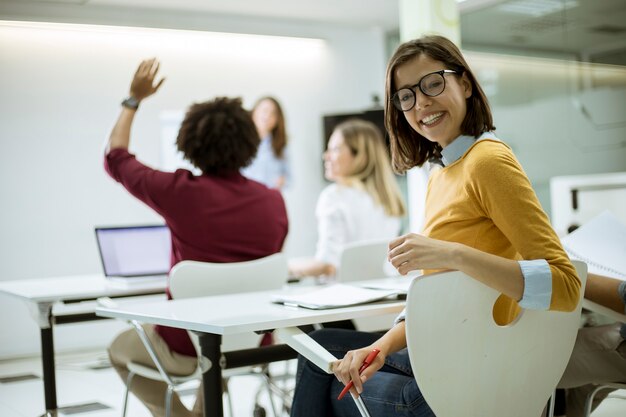 Foto jovem estudante feminino com óculos na sala de aula