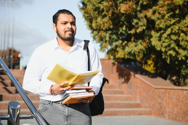 Jovem estudante indiano carregando livros