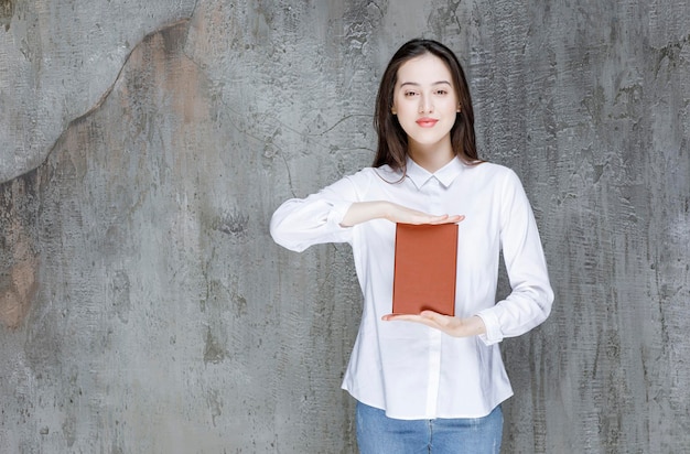 Jovem estudante ou professor mostrando o livro de literatura para a câmera. foto de alta qualidade