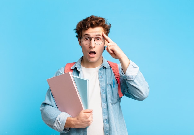 Jovem estudante parecendo surpreso, boquiaberto, chocado, percebendo um novo pensamento, ideia ou conceito