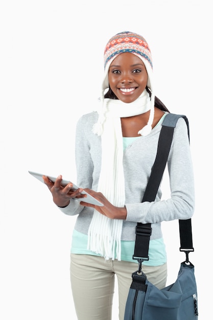 Jovem estudante sorridente em roupas de inverno com o tablet