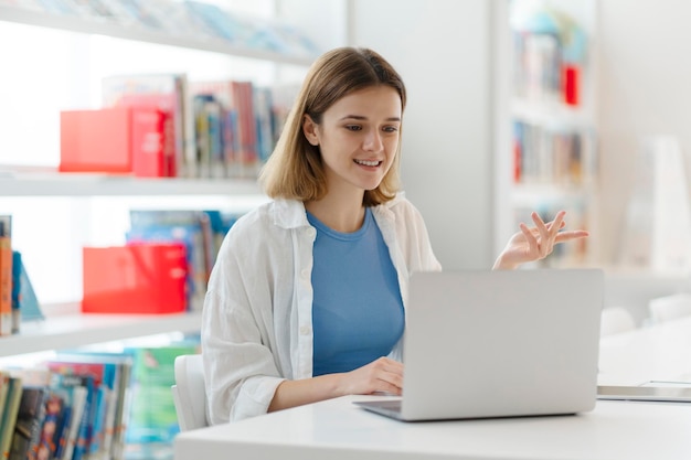 Jovem estudante sorridente estudando aula on-line Mulher de negócios confiante freelancer usando laptop