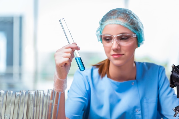 Jovem estudante trabalhando com soluções químicas no laboratório