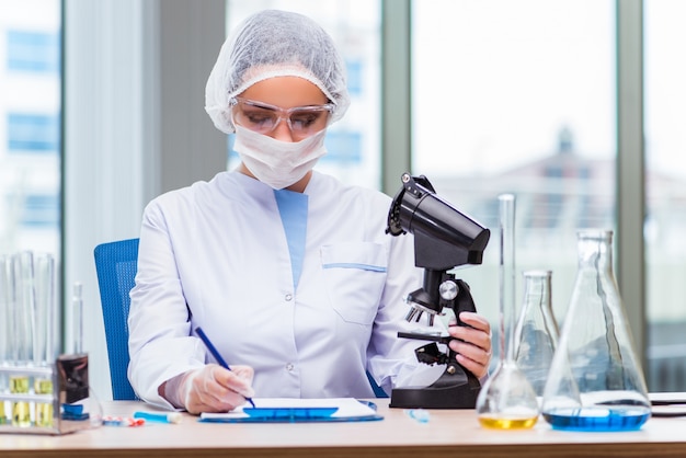 Jovem estudante trabalhando com soluções químicas no laboratório