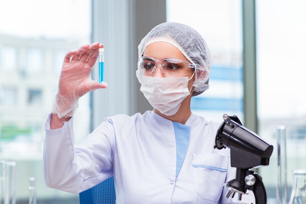 Foto jovem estudante trabalhando com soluções químicas no laboratório