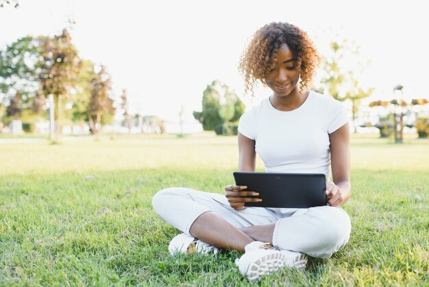 Jovem estudante universitária sentada no gramado