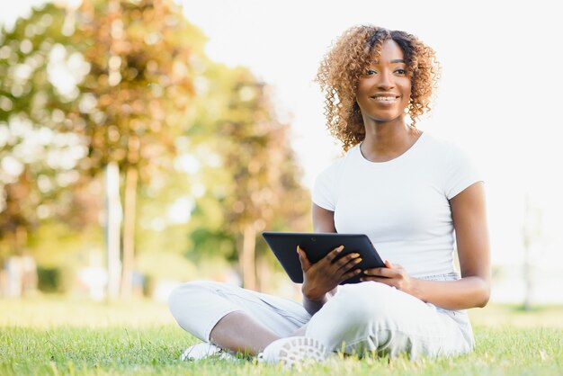 Foto jovem estudante universitária sentada no gramado