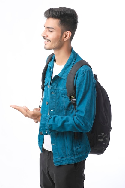 Jovem estudante universitário indiano dando expressão em fundo branco.