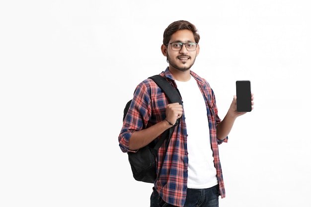 Jovem estudante universitário indiano mostrando tela do smartphone na parede branca