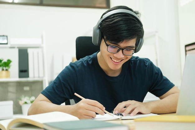 Jovem estudo em frente ao computador portátil em casa