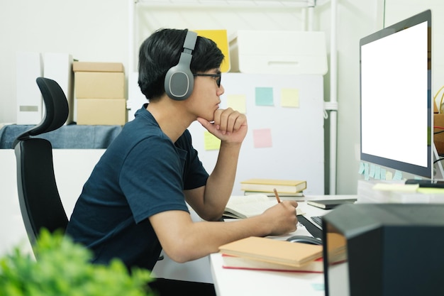 Jovem estudo em frente ao computador portátil em casa