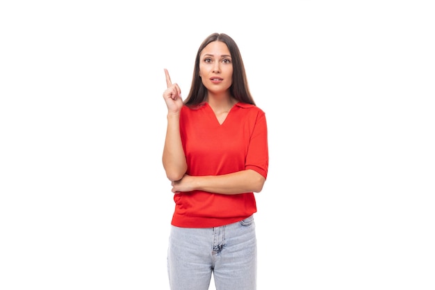 Jovem europeia inteligente de cabelo preto vestida com uma camiseta vermelha tem uma ideia e quer contar