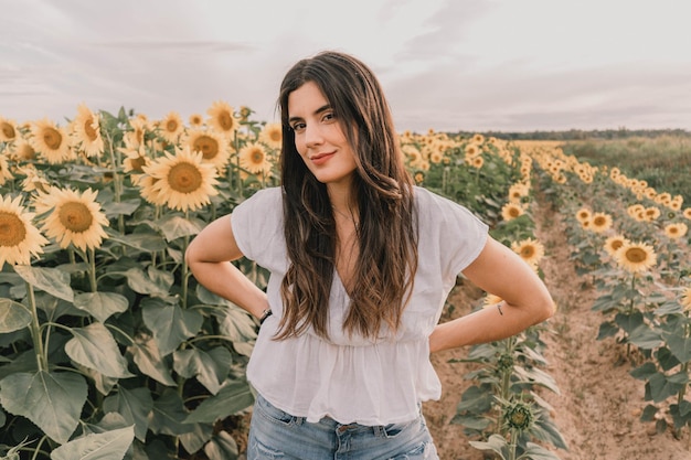 Jovem europeia posando com uma bela paisagem de girassóis em um dia ensolarado