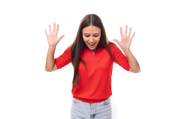 Jovem excitada morena vestida com uma camiseta vermelha em um fundo branco