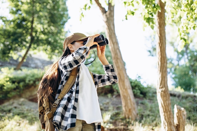 Jovem explorando parques com mochila e binóculos