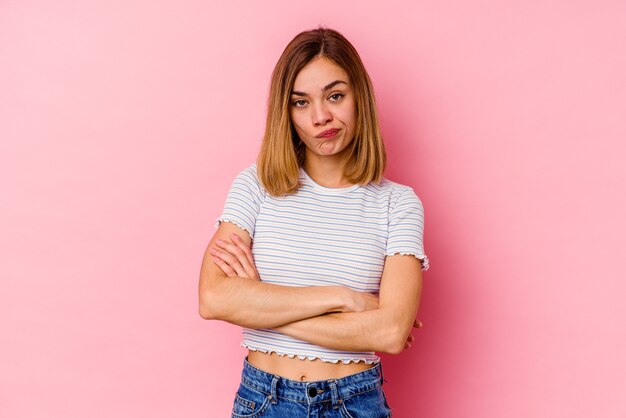 Jovem expressiva posando em fundo rosa