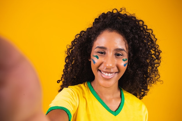 Foto jovem fã afro-brasileira fazendo selfie pronta para o jogo brasileiro