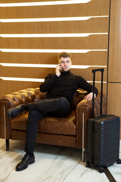 Jovem falando em seu smartphone em um saguão de hotel