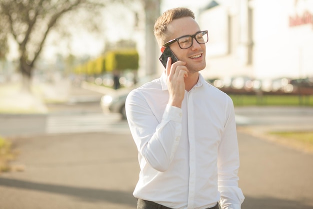 Jovem falando em telefone inteligente enquanto está na cidade