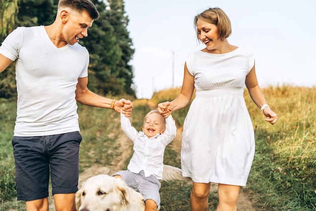 Jovem família feliz com cachorro se divertir ao ar livre