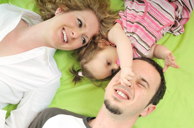 jovem família feliz com lindo bebê brincando e sorriso isolado no branco