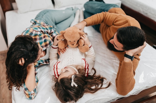 Jovem família feliz comprando nova cama e colchão em grande loja de móveis