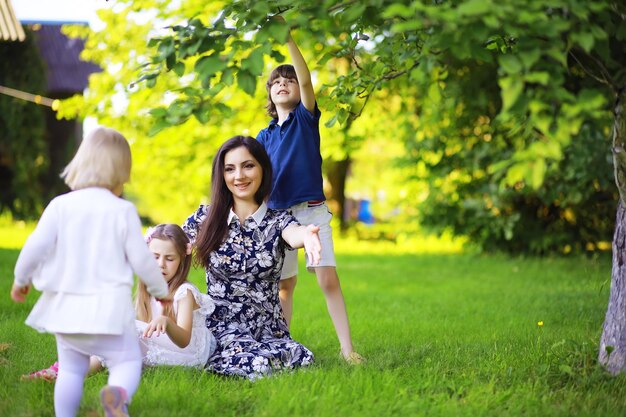 Jovem família grande em uma caminhada matinal de verão Linda mãe com filhos está brincando no parque