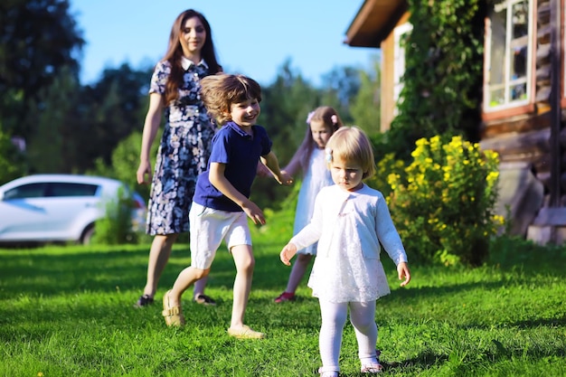 Jovem família grande em uma caminhada matinal de verão Linda mãe com filhos está brincando no parque